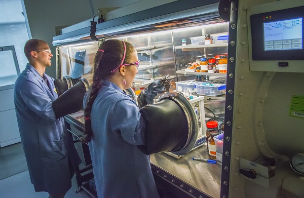 JCAP (Joint Center Artificial Photosynthesis) - Kurt van Allsburg is checking an air-sensitive reaction mixture for crystals inside a controlled-atmosphere glove box while Erin Creel is transferring ferrocene into a vial in the glovebox. Chu Hall, Berkeley Lab -